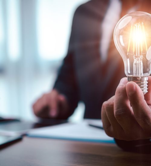 businessman hand holding light bulb with finance document and tool,concept of New ideas for business and fonance.