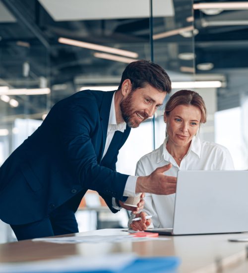 Female boss discussing online project with employee showing presentation to experienced team leader