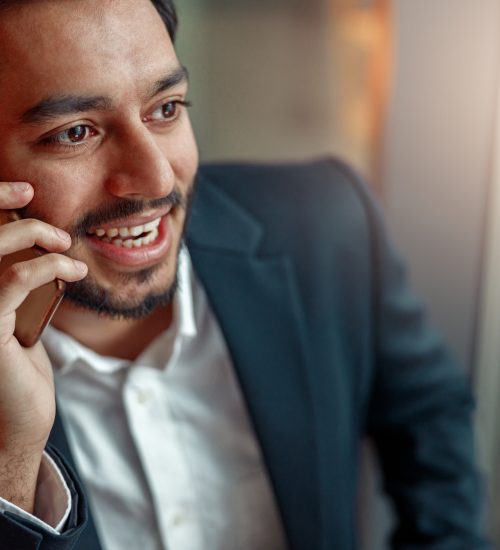 Close up of indian businessman talking by phone with client. High quality photo